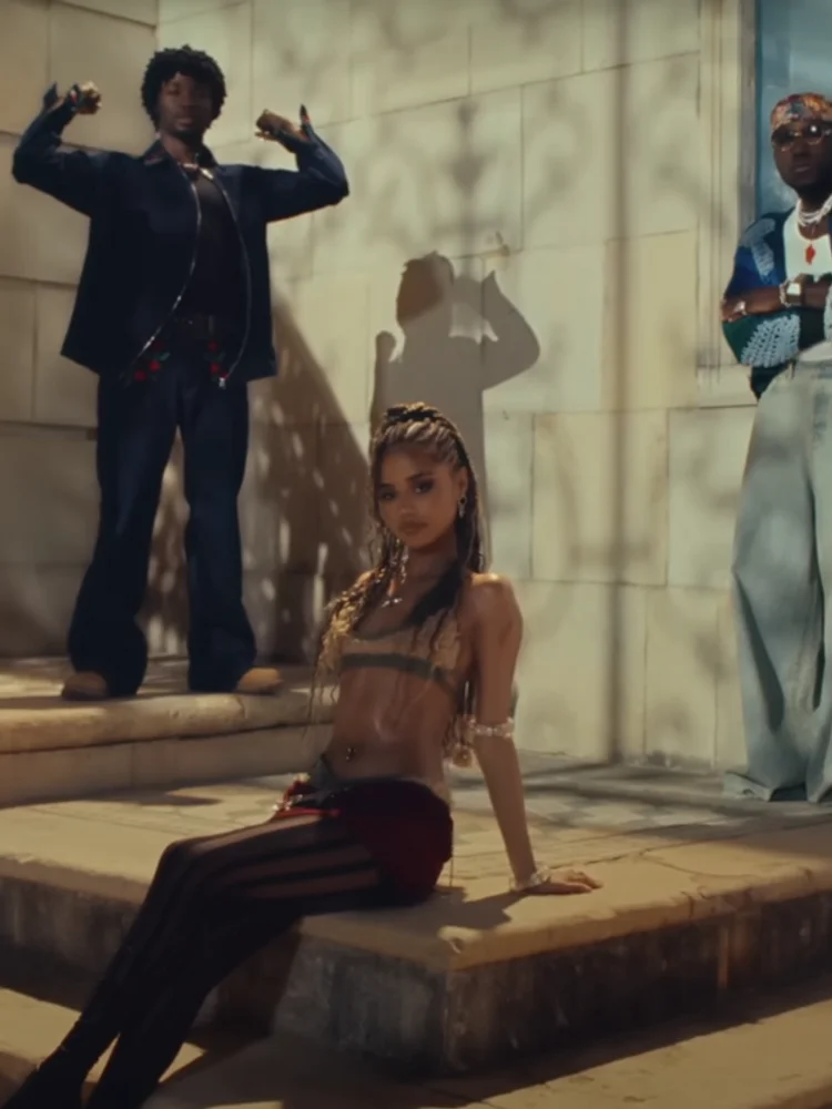 A still from the music video for ‘One Call’ showing Tyla, Omah Lay, and SPINALL.