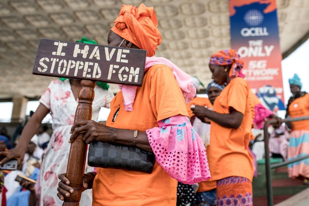 A photo of an anti Female Genital Mutilation (FGM) protester holding a placard outside the National Assembly in Banjul on March 18, 2024, during the debate between lawmakers on a highly controversial bill seeking to lift the ban on FGM.