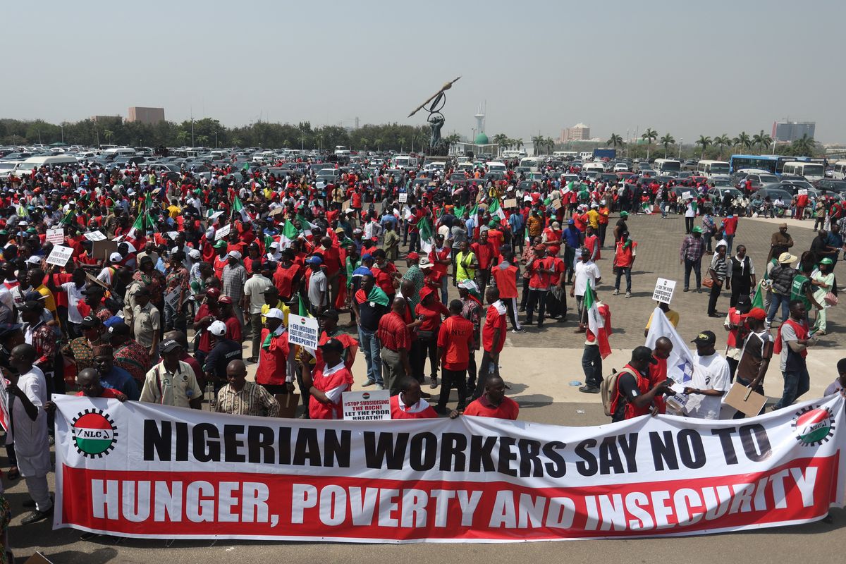 A photo of protestors near the Nigerian National Assembly, with a banner that says, "Nigerian workers say no to hunger, poverty and insecurity."
