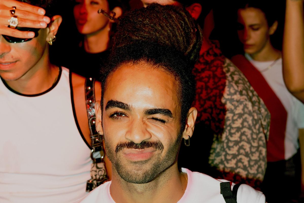 Abokamar photographed in a crowd of dancing people, wearing a white t-shirt.