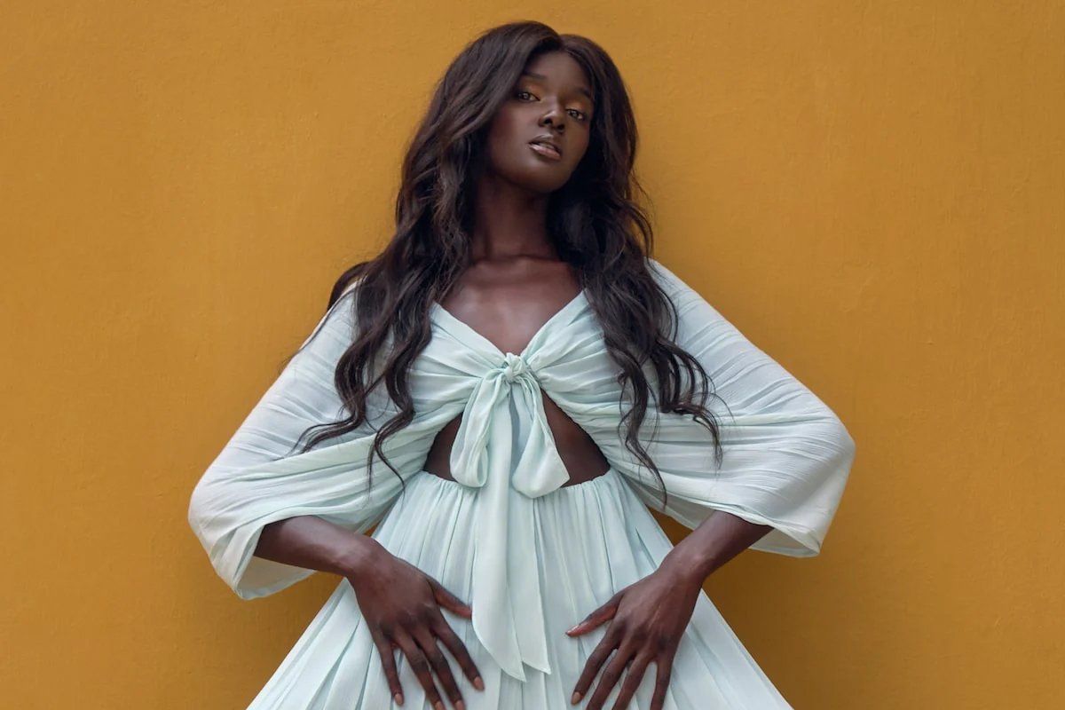 An image of a model wearing a pantsuit that ties in the middle of the chest and has a bare stomach.