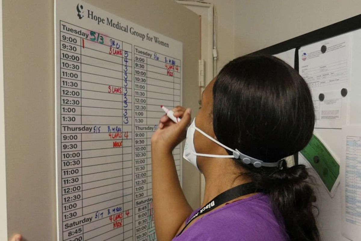 Doctor writing on chart 
