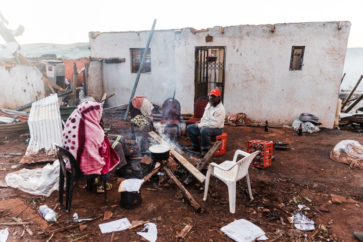Residents prepare breakfast outside their destroyed house in the aftermath of a tornado and extreme weather at an informal settlement in Tongaat, north of Durban on June 04, 2024.