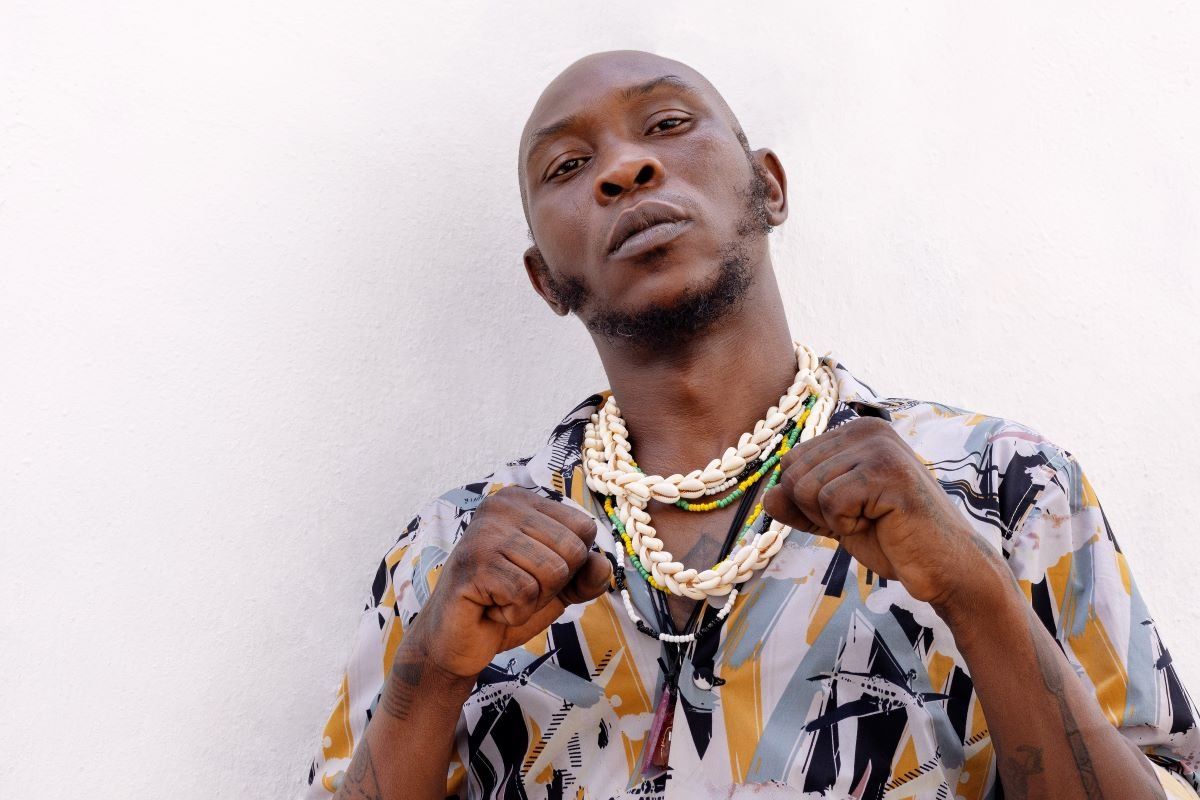 Sean Kuti holding up his necklaces. 